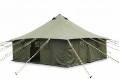 Large green tent on grass with buildings and power lines in the background